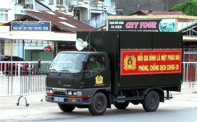 Lực lượng chức năng đẩy mạnh thông tin tuyên truyền ở các địa điểm đông dân cư. (Ảnh: Trung Hiếu/TTXVN) Sóc Trăng đạt mục tiêu chuyển về trạng thái bình thường mới từ 16/9 ảnh 2