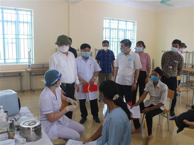 Chủ tịch Ủy ban Nhân dân tỉnh Hà Nam Trương Quốc Huy (thứ 2, trái sang) kiểm tra công tác tiêm vaccine phòng COVID-19 tại thị xã Duy Tiên. (Ảnh: Thanh Tuấn/TTXVN) Hà Nam: Thành phố Phủ Lý giãn cách xã hội theo Chỉ thị số 16 ảnh 1