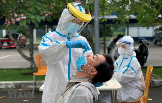 Các y bác sỹ Trung tâm kiểm soát bệnh tật Thành phố Hồ Chí Minh và quận 7 thực hiện xét nghiệm sàng lọc COVID-19. (Ảnh: Thanh Vũ/TTXVN) TP.HCM: Tỷ lệ dương tính với SARS-CoV-2 ở vùng xanh, vùng vàng dưới 1% ảnh 1