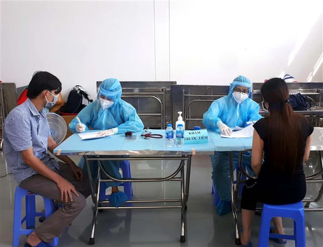 Các công nhân đang làm việc theo phương án '3 tại chỗ' tại Khu chế xuất Tân Thuận, quận 7, Thành phố Hồ Chí Minh kiểm tra y tế trước khi tiêm mũi vaccine thứ 2. (Ảnh: Thanh Vũ/TTXVN) TP Hồ Chí Minh: Hướng phòng, chống dịch và phục hồi kinh tế sau 15/9 ảnh 2