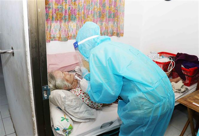 Lực lượng quân y tăng cường tại các xã phường tham gia công tác xét nghiệm COVID-19 cho người dân; tư vấn, chữa bệnh cho F0 tại nhà, vận chuyển bệnh nhân nặng lên điều trị ở tuyến trên. (Ảnh: Xuân Khu/TTXVN) TP.HCM: Trạm y tế lưu động cần đánh giá, phân loại tốt F0 tại nhà ảnh 1
