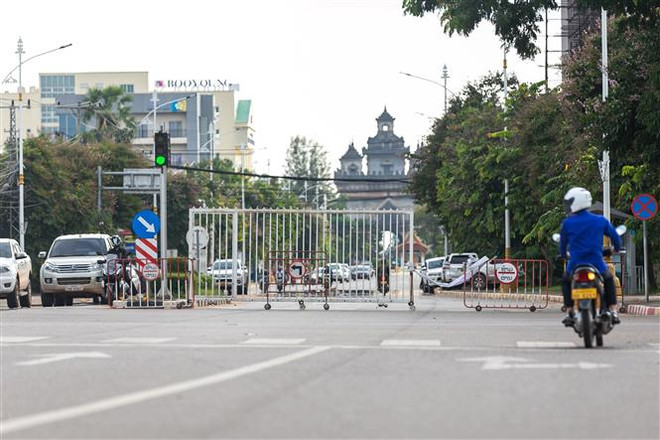Phong tỏa để ngăn chặn sự lây lan của dịch COVID-19 tại một tuyến đường gần công viên giải trí Patuxay ở Vientiane, Lào, ngày 20/9/2021. (Ảnh: THX/TTXVN) Lào ghi nhận thêm nhiều ca lây nhiễm COVID-19 trong cộng đồng ảnh 1