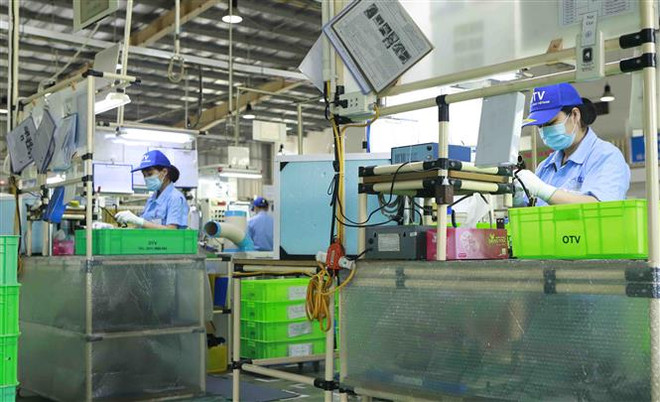 Công nhân làm việc trong một nhà máy ở Vĩnh Phúc. (Ảnh: Quỳnh Hoa/TTXVN) Tháo gỡ khó khăn, thúc đẩy sản xuất, kinh doanh trong bối cảnh dịch ảnh 2