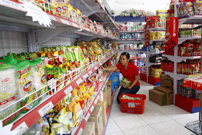 Khách hàng lựa chọn mua lương thực tại cửa hàng tiện ích. (Ảnh: Đình Huệ/TTXVN) Tốc độ "phủ sóng" đến các ngõ ngách của cửa hàng tiện ích ảnh 1