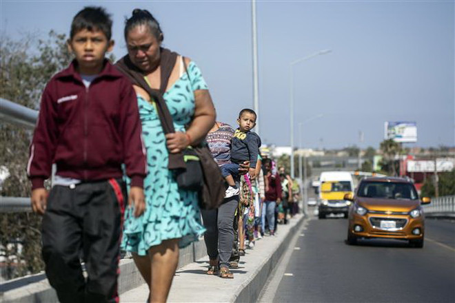 Người di cư tiến về khu vực biên giới Mexico-Mỹ tại bang Baja California (Mexico) ngày 28/4. (Nguồn: AFP/TTXVN) Tổng thống Mỹ ký sắc lệnh nhập cư mới, nói không với dòng người tị nạn ảnh 1