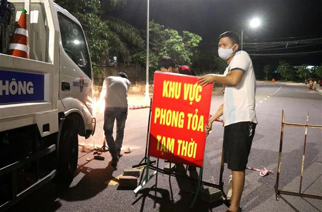 Lực lượng chức năng tháo gỡ biển hiệu phong tỏa Tổ 5A, Khu phố 1, phường Đông Lễ. (Ảnh: Nguyên Lý/TTXVN) Dịch COVID-19: Quảng Trị đã dỡ bỏ gần hết điểm phong tỏa tạm thời ảnh 1