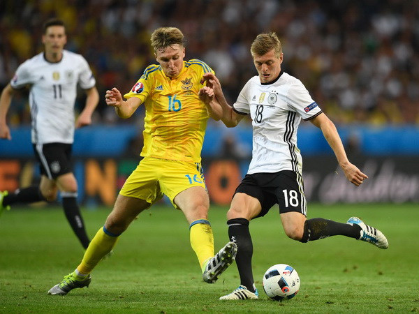 Trung vệ Toni Kroos (phải) đội tuyển Đức tranh bóng với trung vệ Serhiy Sydorchuk của đội tuyển Ukraine. (Nguồn: AFP/TTXVN) Giải mã chiến thắng của đội tuyển Đức trong trận ra quân EURO 2016 ảnh 1
