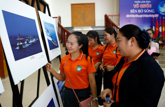 Sinh viên Học viện Mỹ thuật Quốc gia Lào tham quan Triển lãm ảnh nghệ thuật "Tổ quốc bên bờ sóng" tại Vientiane, Lào. (Ảnh: Phạm Kiên/TTXVN) ttxvn_trien_lam_2.jpg