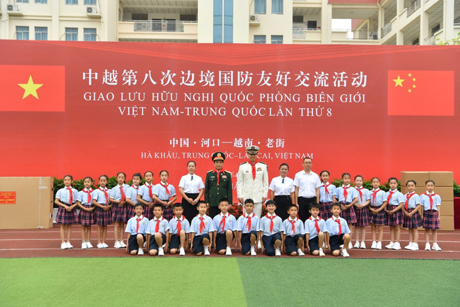Bộ trưởng Quốc phòng Trung Quốc Đổng Quân và Bộ trưởng Quốc phòng Phan Văn Giang chụp ảnh lưu niệm cùng giáo viên, học sinh trường Tiểu học huyện Hà Khẩu. (Ảnh: TTXVN phát) ttxvn_bien_gioi_viet_trung.jpg