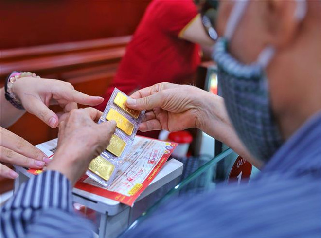 Giao dịch vàng tại Công ty Vàng bạc Đá quý Bảo Tín- Minh Châu. Ảnh: (Ảnh: Danh Lam/TTXVN) Thị trường vàng tuần tới có thể vẫn còn tâm lý không mấy lạc quan ảnh 1