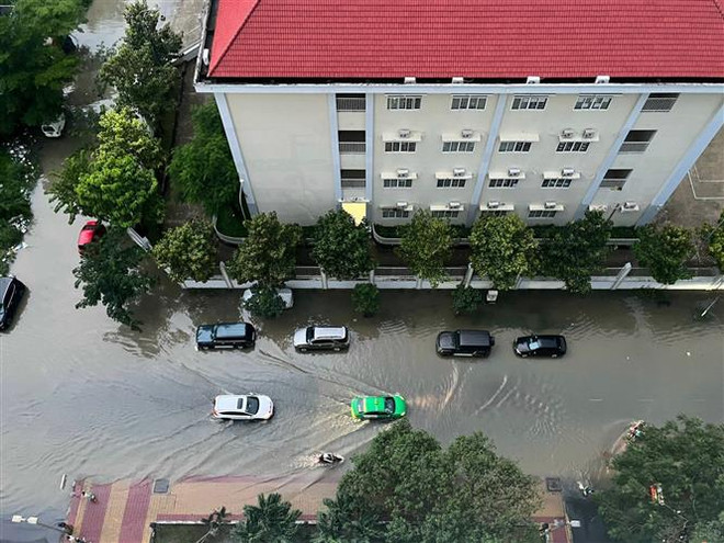 Một khu dân cư trên đường Nguyễn Lương Bằng (Quận 7) bị bao quanh bởi “biển nước” do mưa lớn và triều cường. (Ảnh: Thu Hương/TTXVN) ttxvn_chong_ngap.jpeg