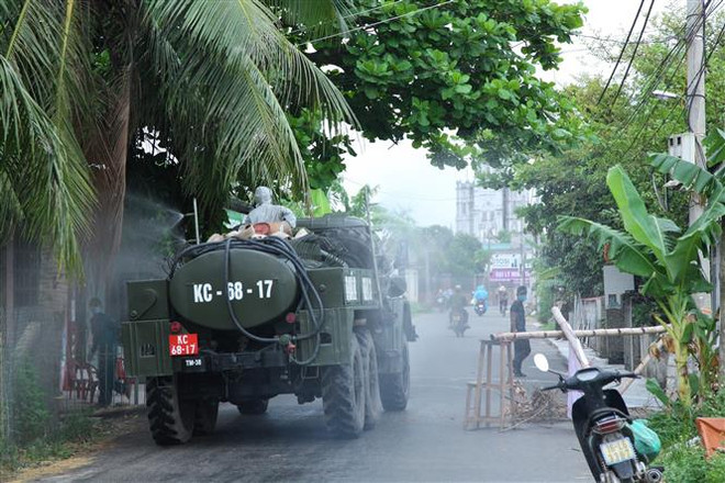 Trung tâm Kiểm soát bệnh tật Hải Phòng, Phòng Hóa học-Bộ Tư lệnh Quân khu 3 và Ủy ban Nhân dân huyện Vĩnh Bảo phun thuốc khử trùng tiêu độc tại khu vực liên quan đến các ca dương tính với SARS-CoV-2. (Ảnh: TTXVN) Hải Phòng yêu cầu công nhân người Vĩnh Bảo tạm ở lại địa phương ảnh 1