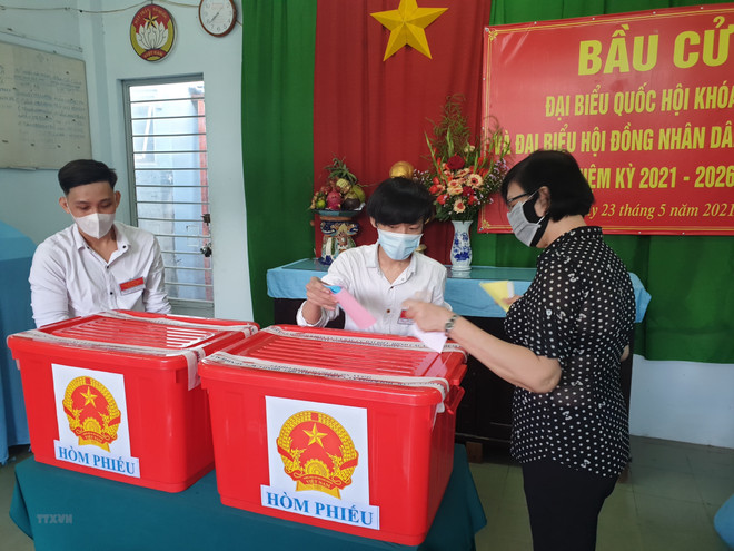 Các cử tri tại điểm phiếu số 10, khu phố chợ phường Lái Thiêu, thành phố Thuận An (Bình Dương) đi bầu cử. (Ảnh: Huyền Trang/TTXVN) Bình Dương không xác nhận tư cách hai người trúng cử đại biểu HĐND ảnh 1