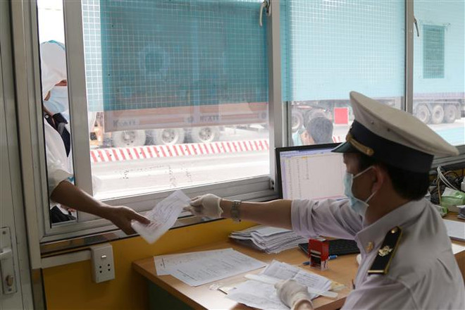 Kiểm dịch Y tế Quốc tế tỉnh Lạng Sơn kiểm tra giấy tờ xét nghiệm COVID-19 đối với lái xe ra vào Cửa khẩu Quốc tế Hữu Nghị. (Ảnh: Quang Duy/TTXVN) Thương mại vùng biên mậu Việt-Trung: Linh hoạt trong điều hành ảnh 2