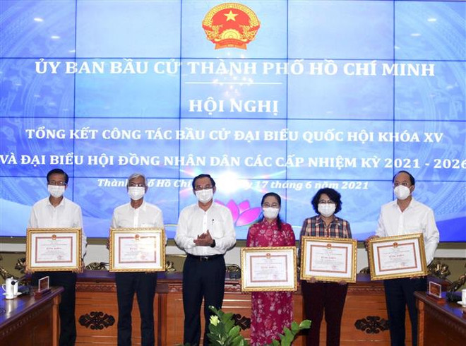 Bí thư Thành ủy Thành phố Hồ Chí Minh Nguyễn Văn Nên (thứ 3 từ trái sang) trao Bằng khen của Chủ tịch Ủy ban Nhân dân Thành phố cho các cá nhân có thành tích xuất sắc trong công tác chuẩn bị, tổ chức bầu cử. (Nguồn: TTXVN phát) Sự tham gia tích cực của nhân dân góp phần vào thành công của bầu cử ảnh 1