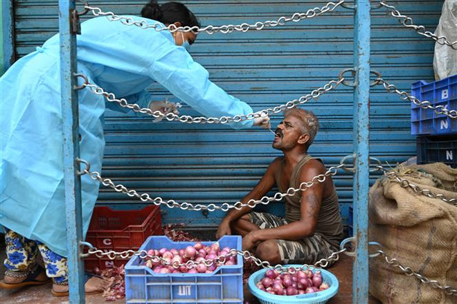 Nhân viên y tế lấy mẫu xét nghiệm COVID-19 cho người dân ở Chennai, Ấn Độ, ngày 1/6/2021. (Nguồn: AFP/TTXVN) Xác suất nhiễm biến thể Delta cao hơn nhiều so với virus thông thường ảnh 1