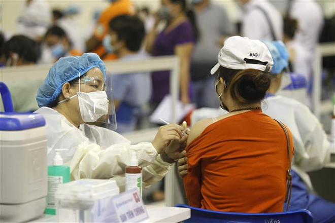 Người lao động Thành phố Hồ Chí Minh được tiêm vaccine phòng COVID-19. (Ảnh: Thanh Vũ/TTXVN) Hai nhiệm vụ nặng nề của Thành phố Hồ Chí Minh trong tuần qua ảnh 1