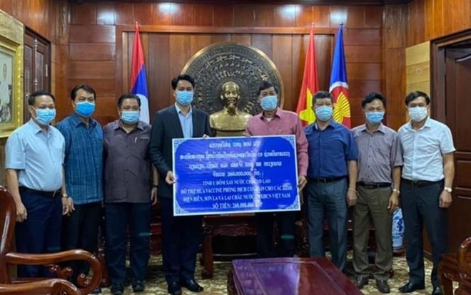 Đại diện Chính quyền tỉnh Oudomsay trao tiền hỗ trợ 3 tỉnh của Việt Nam ứng phó với dịch bệnh COVID-19. (Ảnh: Tổng Lãnh sự quán Việt Nam tại Luang Prabang cung cấp) Nhân dân Lào chung tay cùng các địa phương Việt Nam phòng chống dịch ảnh 1
