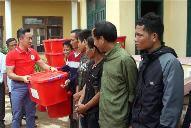 Ông Nguyễn Hải Anh, Phó Chủ tịch, Tổng Thư ký Hội Chữ thập Đỏ Việt Nam, trao tặng thùng đồ dùng gia đình cho các hộ gia đình ở Quảng Trị. (Ảnh: Trịnh Bang Nhiệm/TTXVN) Làm gì để ngăn chặn vấn nạn lạm dụng biểu tượng Chữ thập Đỏ? ảnh 2