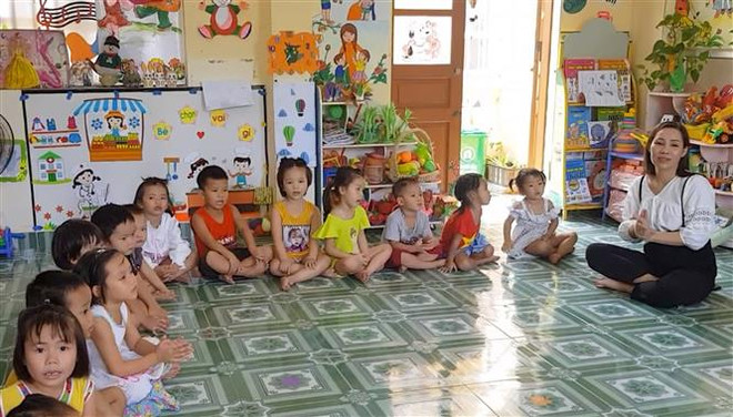 Cô giáo Lưu Thị Thoa đang cùng các cháu bé lớp mầm non 2- 3 tuổi Trường mầm non Bạch Long Vỹ sinh hoạt văn nghệ. (Ảnh: Minh Thu/TTXVN) Thầy cô 'dành cả thanh xuân' ươm mầm tương lai trên đảo Bạch Long Vỹ ảnh 2