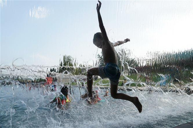 Trẻ em tránh nóng trong công viên tại Washington D.C., Mỹ, ngày 21/7/2019. (Nguồn: THX/TTXVN) Mức tăng nhiệt độ trung bình toàn cầu sắp chạm ngưỡng giới hạn ảnh 1
