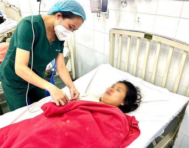 Bác sỹ thăm khám cho sản phụ sau ca sinh non do sốt xuất huyết. (Ảnh: TTXVN phát) Cứu sống sản phụ bị sốt xuất huyết nặng, sinh non ở tuần thai 35 ảnh 1