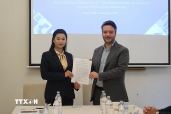 Chị Nguyễn Thị Bích Diệp của ASVI và Francesco Maringiò của Fondazione Italy-Vietnam ký thỏa thuận hợp tác. (Ảnh: Trường Dụy/TTXVN)