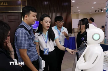 Các đại biểu trải nghiệm công nghệ tại khu trưng bày của Hội thảo. (Ảnh: Tiến Lực/TTXVN)