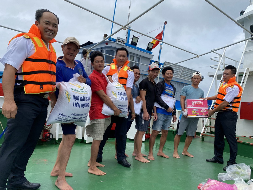 Các chiến sỹ hải quân công tác trên huyện đảo Trường Sa hỗ trợ lương thực, thực phẩm cho ngư dân Bình Thuận. (Ảnh: TTXVN phát)