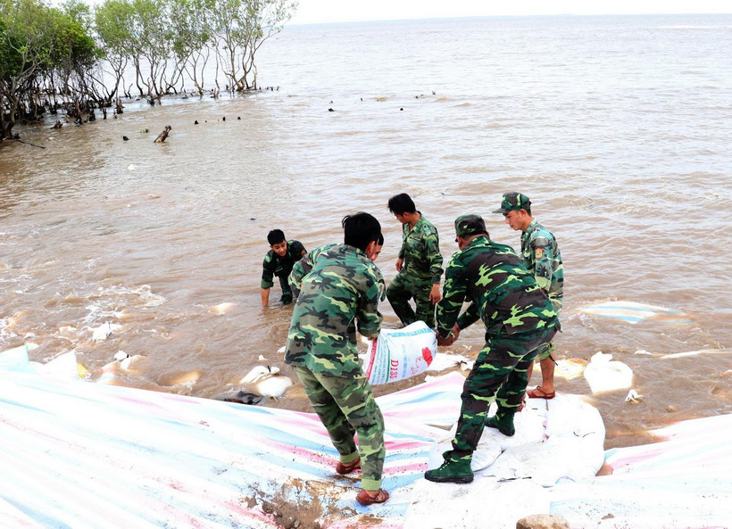 Các chiến sỹ sử dụng bao cát để gia cố chân đê biển Gò Công, tỉnh Tiền Giang năm 2018. (Ảnh: Nam Thái/TTXVN)