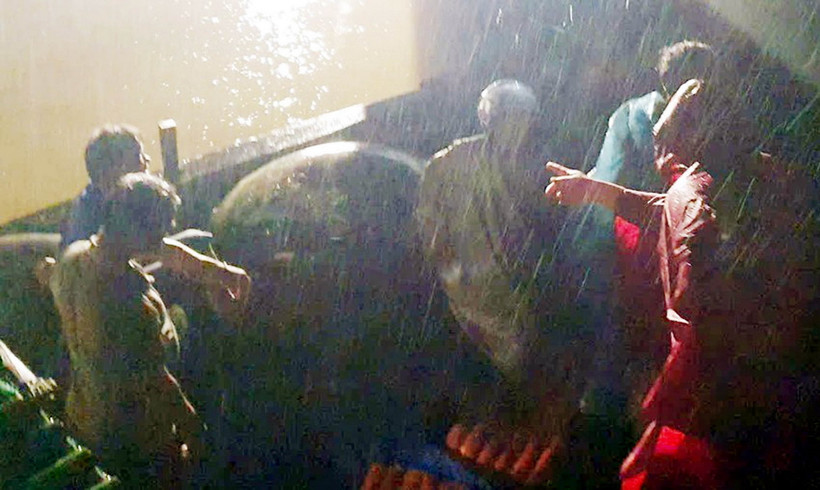 Các lực lượng chức năng và ngư dân ứng cứu thành công 2 ngư dân bị chìm tàu trong điều kiện thời tiết xấu, đêm tối. (Ảnh: TTXVN phát)