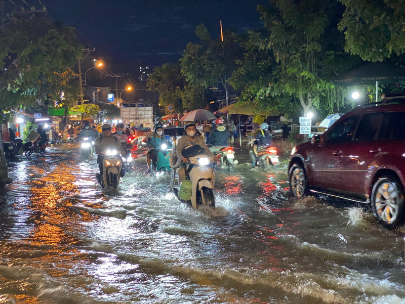 Các phương tiện di chuyển khó khăn khi triều cường gây ngập trên đường Trần Xuân Soạn, quận 7. (Ảnh: Hồng Giang/TTXVN)