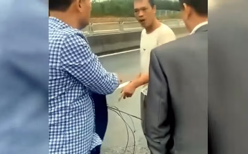 Ông Phạm Văn Sỹ căng dây chắn ngang đường cao tốc Tuyên Quang-Phú Thọ gây nguy hiểm cho các phương tiện lưu thông trên tuyến. (Ảnh cắt từ clip trên trang mạng xã hội)