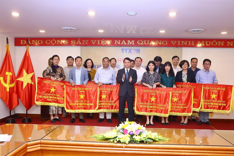 Ủy viên Trung ương Đảng, Bí thư Đảng ủy, Tổng giám đốc TTXVN Nguyễn Đức Lợi tặng Cờ thi đua của TTXVN cho 21 tập thể. (Ảnh: Minh Quyết/TTXVN)