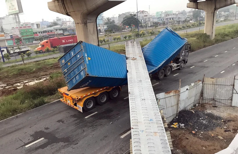 Xe container bị dầm bêtông đè lên dập móp. (Ảnh: TTXVN phát)