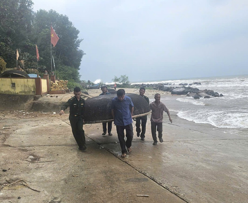 Các cán bộ, chiến sỹ Đồn Biên phòng Cửa Tùng hỗ trợ người dân di chuyển tàu thuyền nhỏ vào nơi trú ẩn an toàn. (Ảnh: TTXVN phát)