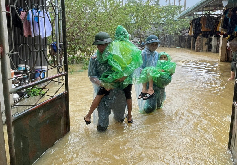 Lực lượng chức năng giúp người dân Chương Mỹ (Hà Nội) di chuyển đến những nơi an toàn. (Ảnh: TTXVN phát)
