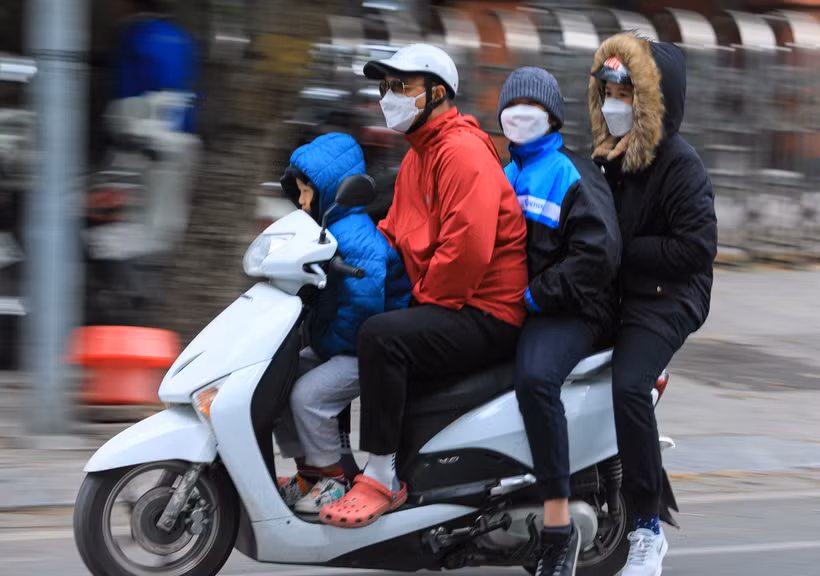 Người dân di chuyển trên đường cảm nhận rõ cái lạnh khi nhiệt độ giảm dưới 14 độ C kết hợp với gió mạnh. (Ảnh: Hoàng Hiếu/TTXVN)