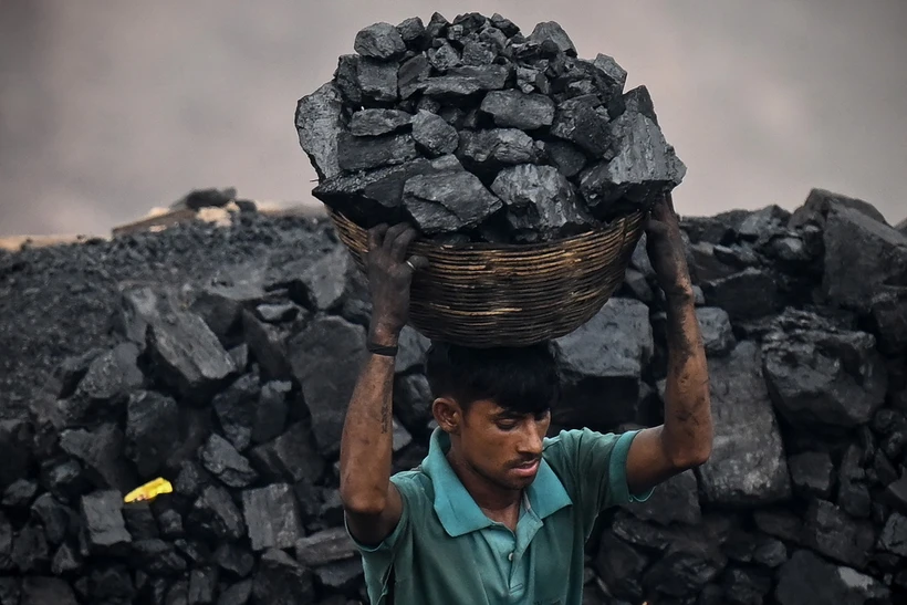 Thu nhặt than đá tại một khu mỏ ở ngoại ô Dhanbad, Ấn Độ. (Ảnh: AFP/TTXVN) 