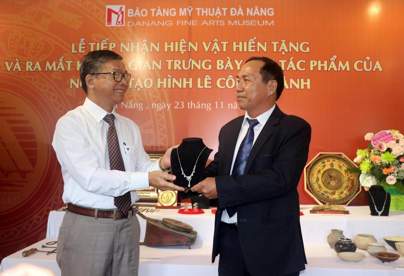 Giám đốc Bảo tàng Mỹ Thuật Đà Nẵng Hà Thanh Vân (trái) nhận các hiện vật do người dân hiến tặng tại buổi lễ. (Ảnh: Trần Lê Lâm/TTXVN)