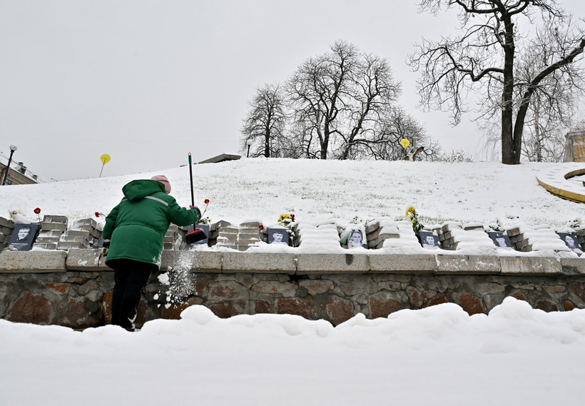 Người dân thu dọn tuyết tại một nghĩa trang ở Kiev, Ukraine. (Ảnh: AFP/TTXVN)