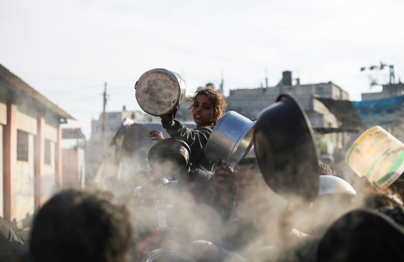 Em nhỏ xếp hàng chờ được phát thực phẩm cứu trợ tại Rafah, Dải Gaza. (Ảnh: THX/TTXVN)