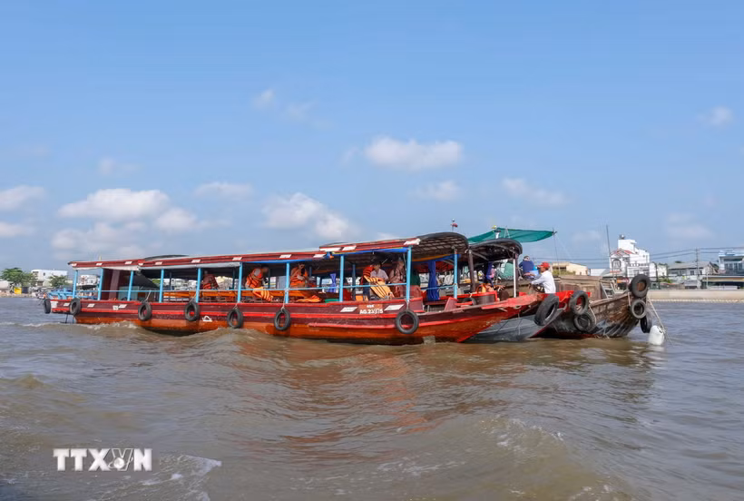 Hai du khách người Mỹ thưởng thức bữa sáng trên ghe ở Chợ nổi Cái Răng. (Ảnh: Thanh Liêm/TTXVN)