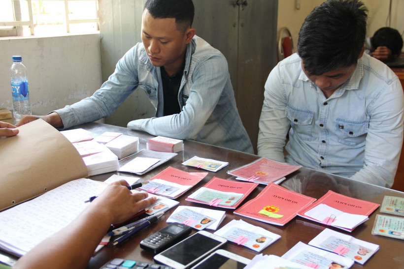 Các đối tượng cho vay nặng lãi cùng tang vật tại Công an phường 4, thành phố Tây Ninh. (Ảnh: Thanh Tân/TTXVN)