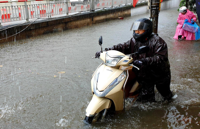 Tuyến đường Trần Hưng Đạo, thành phố Nam Định ngập sâu, khiến người và phương tiện tham gia giao thông gặp nhiều khó khăn ngày đầu năm. (Ảnh: Văn Đạt/TTXVN) 