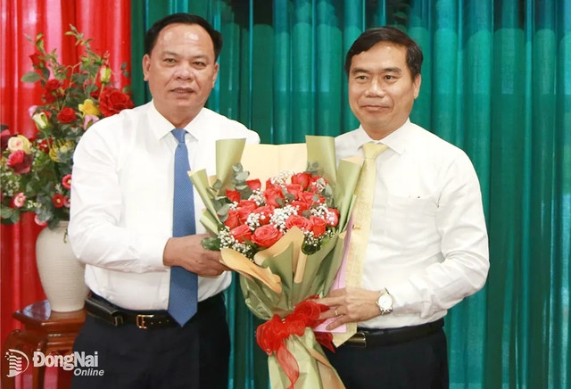Quyền Chủ tịch Ủy ban Nhân dân tỉnh Võ Tấn Đức trao quyết định và tặng hoa chúc mừng Quyền Chủ tịch Ủy ban Nhân dân huyện Nhơn Trạch Nguyễn Thế Phong. (Nguồn: Báo Đồng Nai)