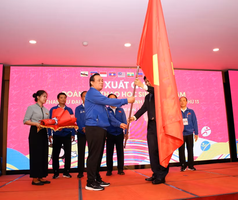 Ông Nguyễn Thanh Đề, Vụ trưởng Vụ Giáo dục thể chất, Bộ Giáo dục và Đào tạo trao cờ Tổ quốc cho ông Trần Văn Lam, Phó Vụ trưởng Vụ Giáo dục thể chất, Bộ Giáo dục và Đào tạo, Trưởng Đoàn Thể thao học sinh Việt Nam tại lễ xuất quân. (Ảnh: Trần Lê Lâm/TTXVN)