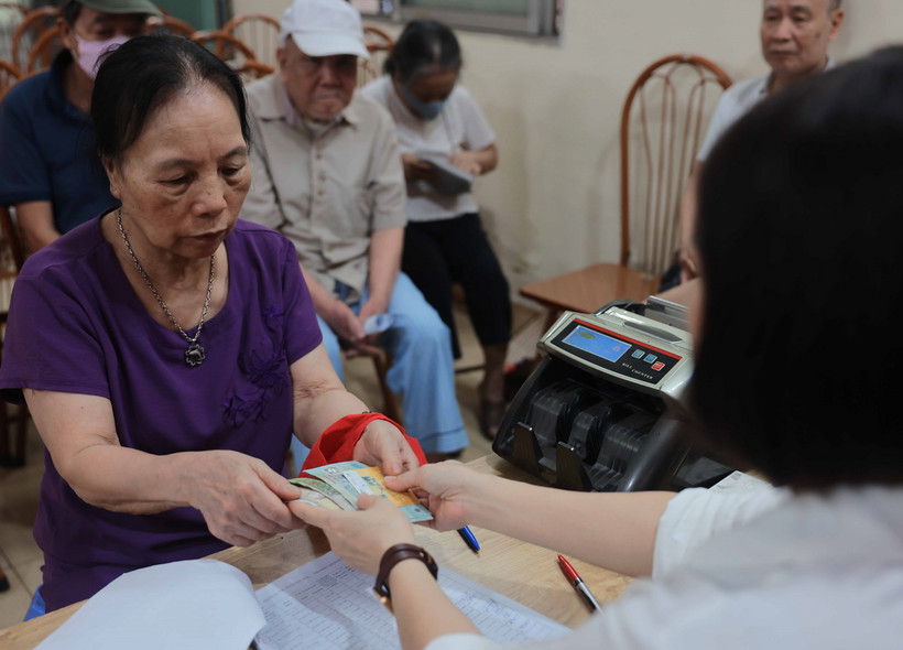 Chi trả cho người nhận lương hưu, trợ cấp BHXH tại điểm Nhà văn hóa khu dân cư số 3A-3B Thanh Lương, quận Hai Bà Trưng, Hà Nội. (Ảnh: Hoàng Hiếu/TTXVN)