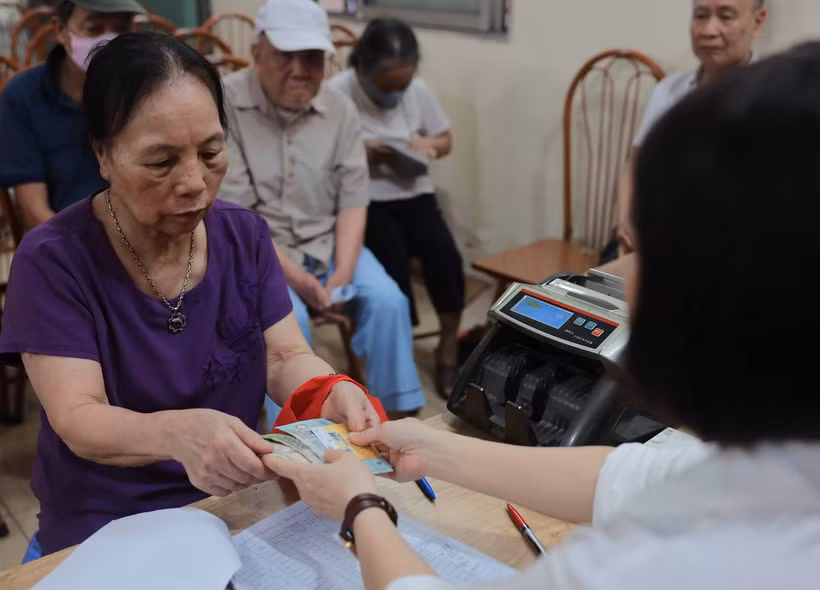 Chi trả cho người nhận lương hưu, trợ cấp BHXH tại điểm Nhà văn hóa khu dân cư số 3A-3B Thanh Lương, quận Hai Bà Trưng, Hà Nội. (Ảnh: Hoàng Hiếu/TTXVN)