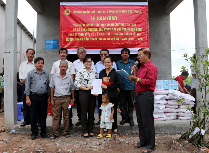 Lãnh đạo xã An Thạnh Nam, huyện Cù Lao Dung trao Quyết định tặng nhà Đại đoàn kết cho hộ ông Đặng Văn Dện. (Ảnh: Trung Hiếu/TTXVN)